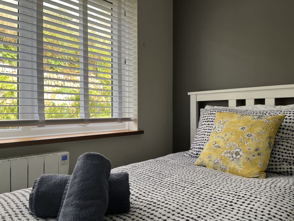 A bedroom with a bed and decorative pillow at Stonecroft in Praa Sands
