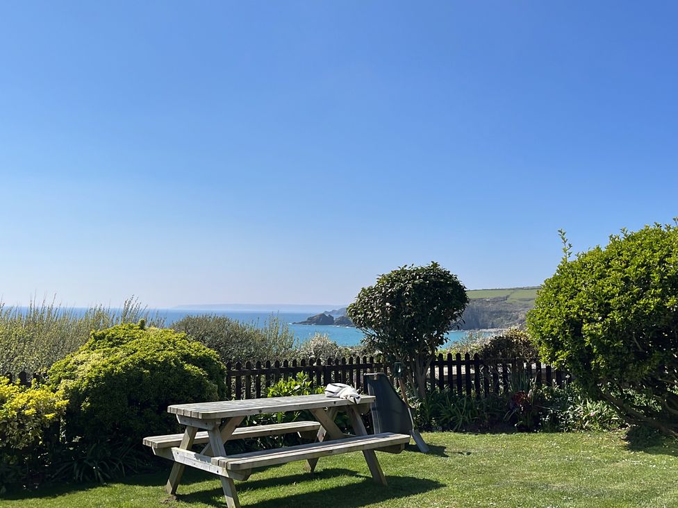 A garden with a picnic table and sea view at Stonecroft in Praa Sands