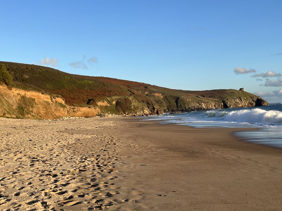 A beach with waves washing onto the shore at Stonecroft in Praa Sands