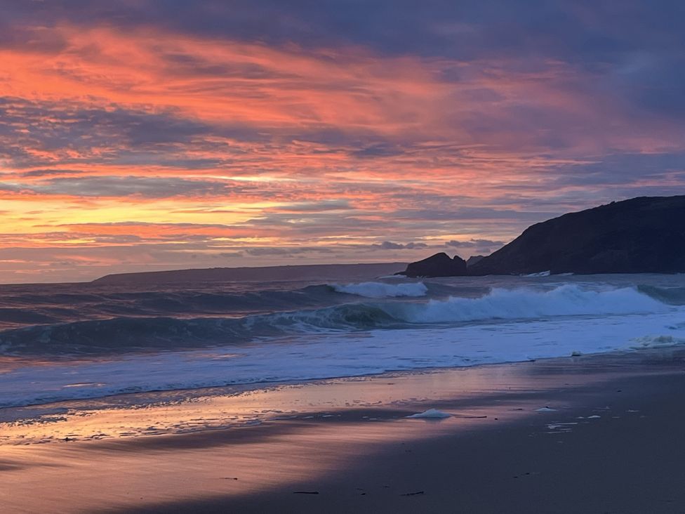 A beach at sunset with waves and hills at Stonecroft in Praa Sands