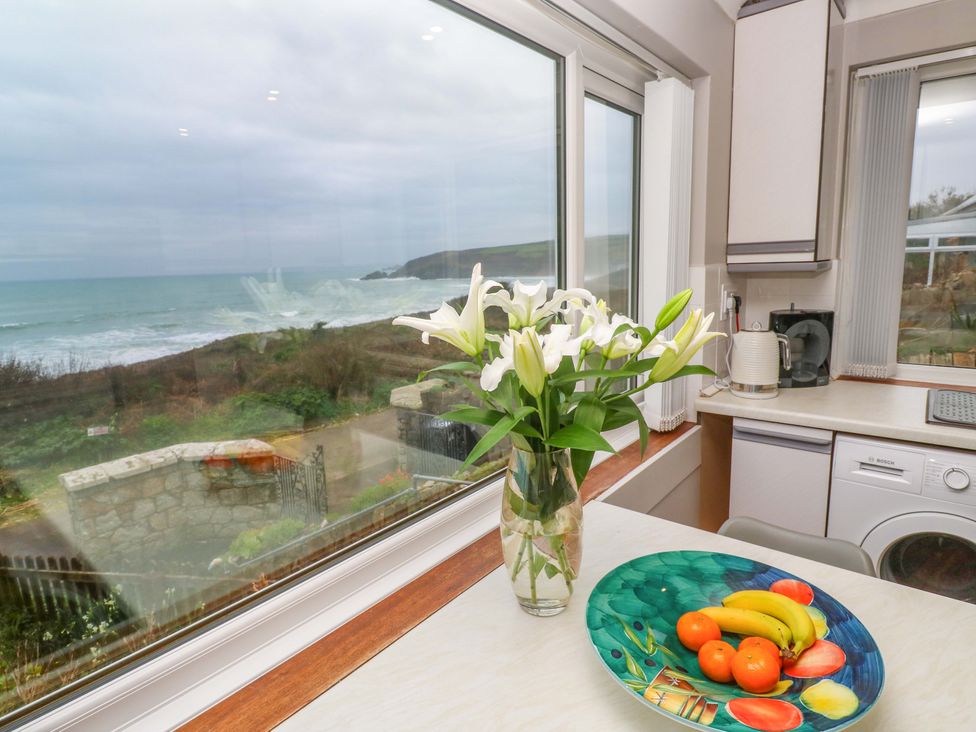 A kitchen with a fruit bowl and flowers at Stonecroft in Praa Sands