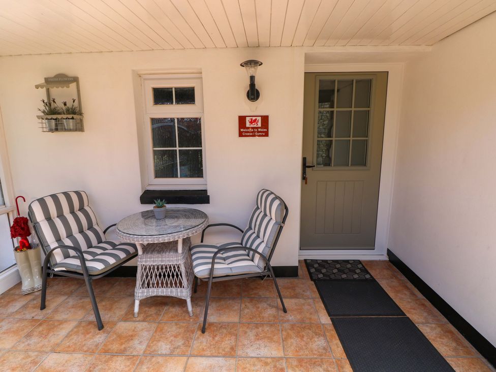 An outdoor seating area with chairs and a table at The Stables in St Athan