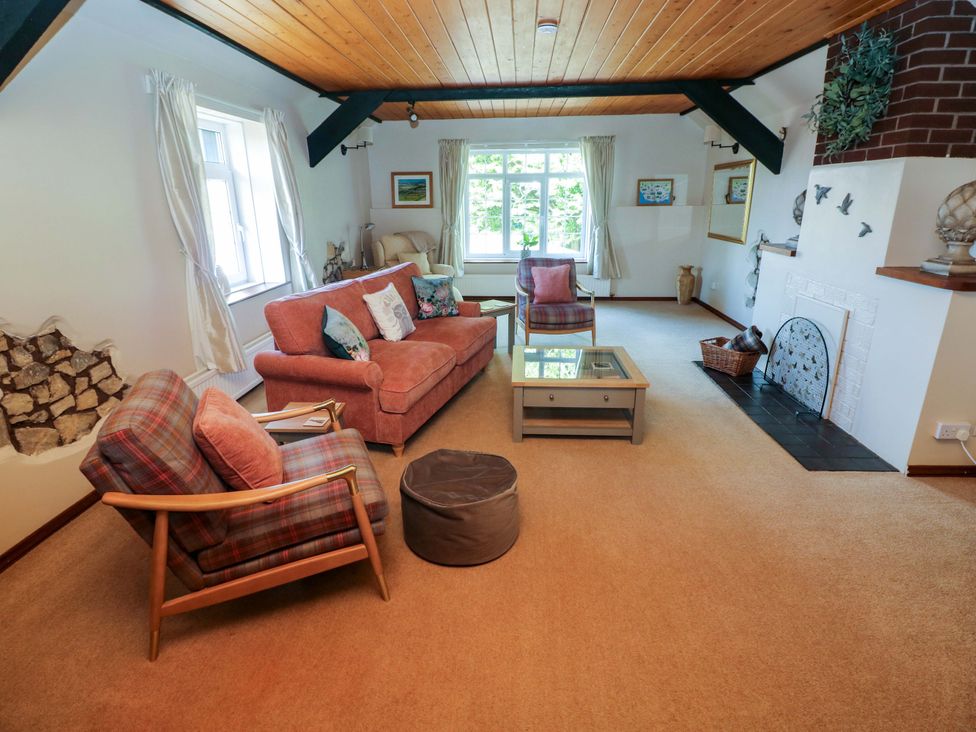 A living room with seating and a fireplace at The Stables in St Athan