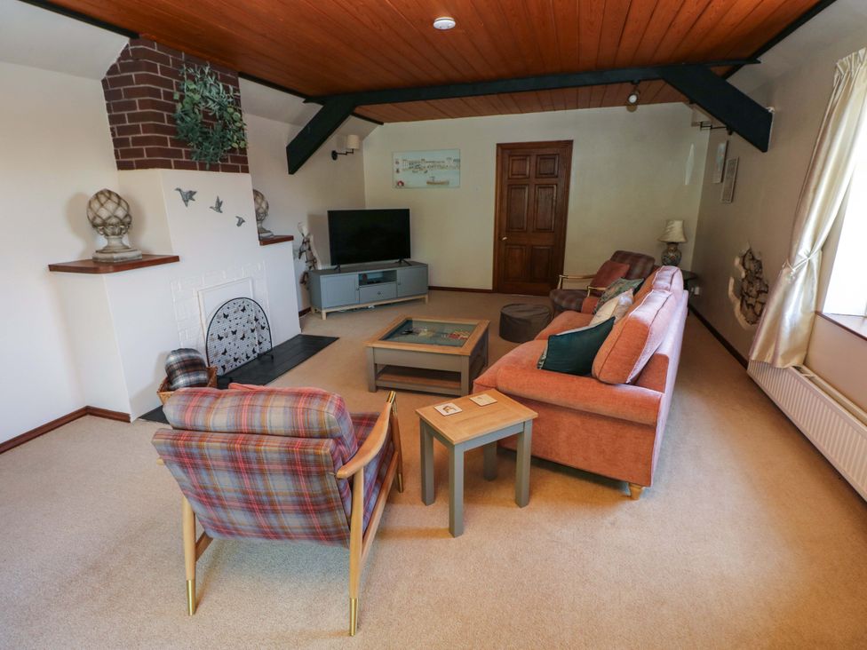 A living room with a sofa and armchair at The Stables in St Athan