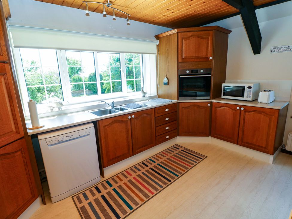 A kitchen with cabinets, sink, and appliances at The Stables in St Athan