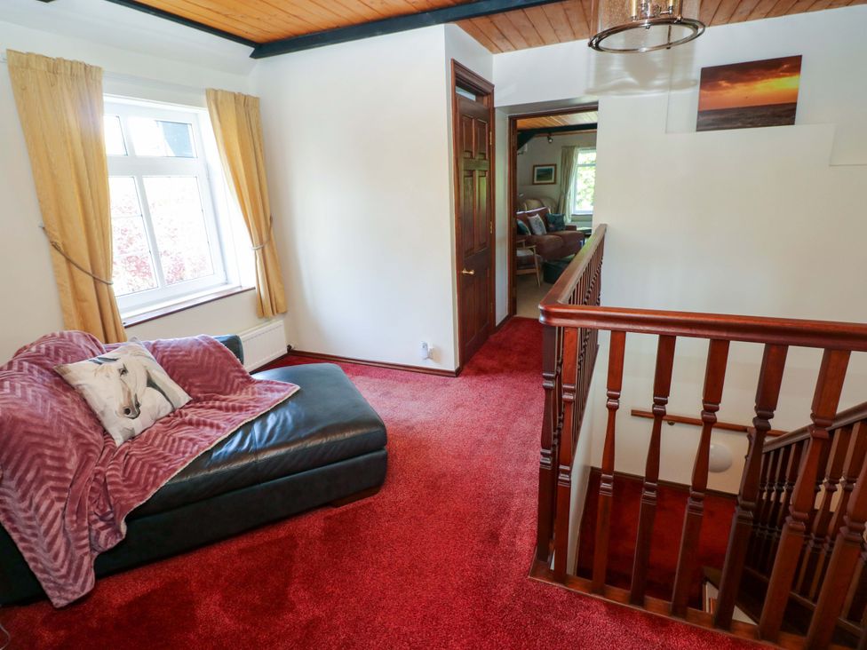 A hallway with a sofa and staircase at The Stables in St Athan