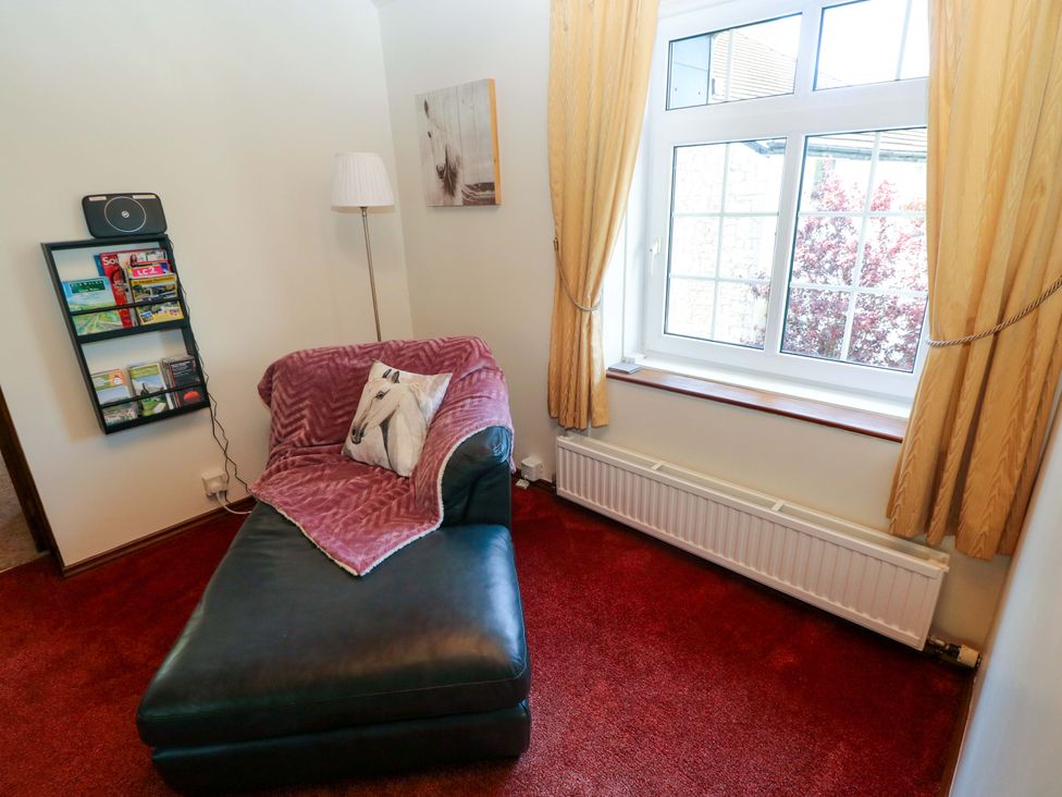 A snug area with a chaise lounge and a shelf at The Stables in St Athan