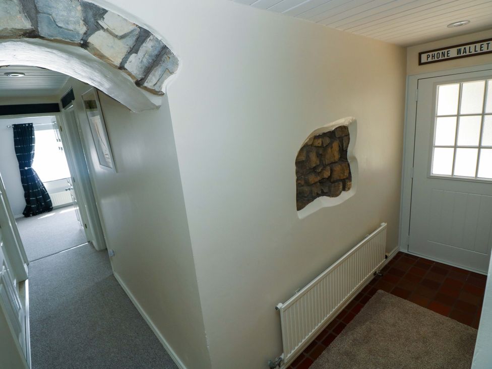 A hallway with a radiator and an entrance door at The Stables in St Athan