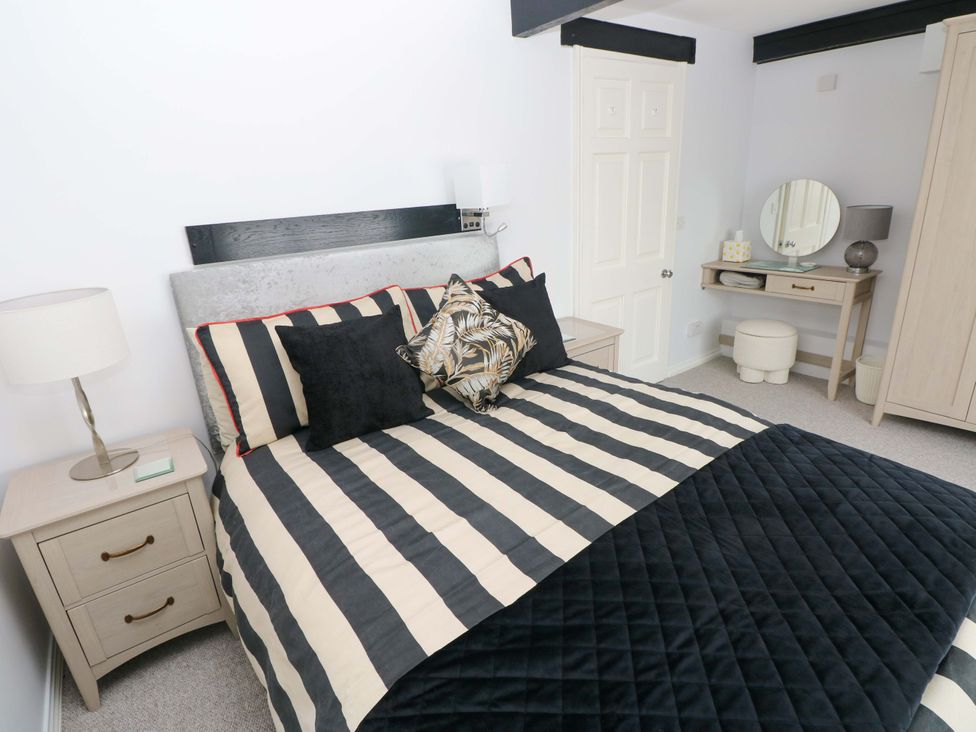 A bedroom with a bed and bedside table at The Stables in St Athan