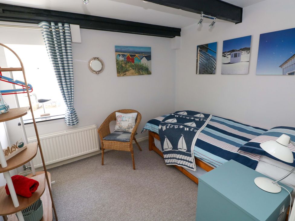 A bedroom with a bed and a chair at The Stables in St Athan