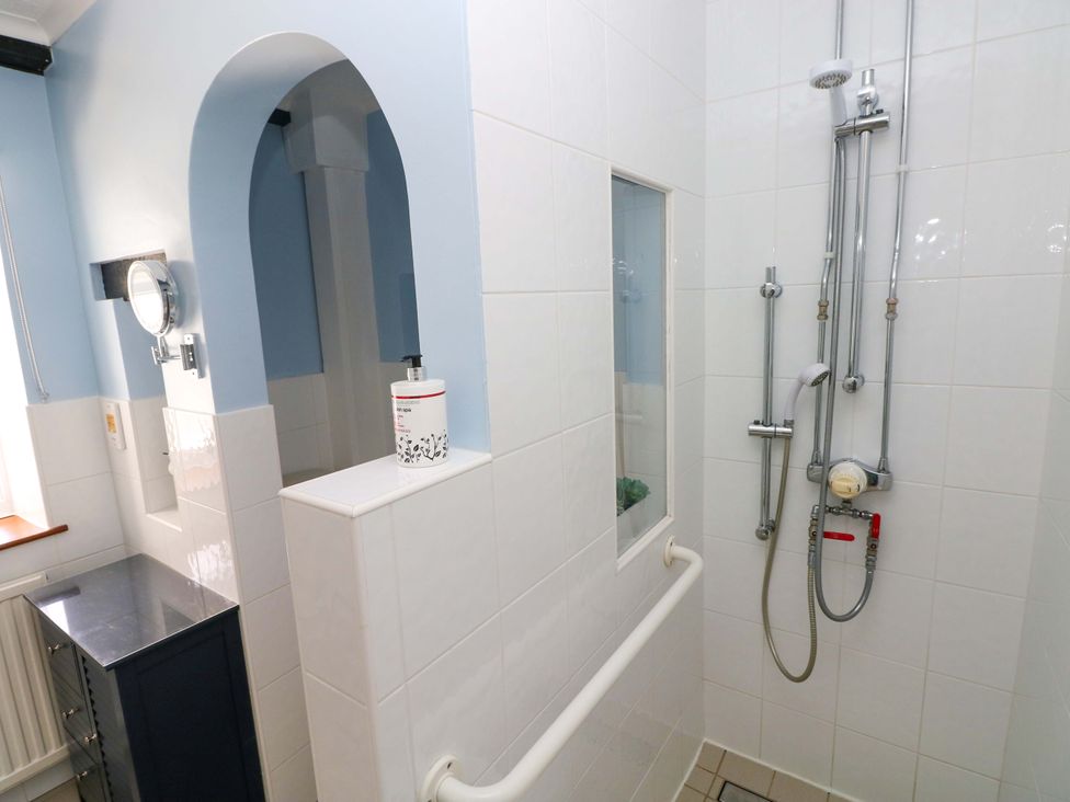 A bathroom with a shower and mirror at The Stables in St Athan