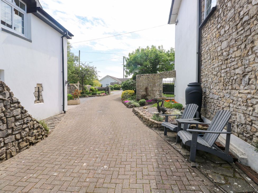 A pathway with stone walls and plants at The Stables St Athan