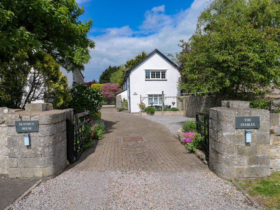 An entrance with a pathway and gates leading to a house at The Stables in St Athan