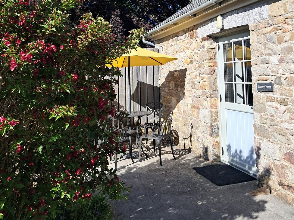 An outdoor seating area with a table and chairs at Carreg Cennen Cottage in Llandeilo