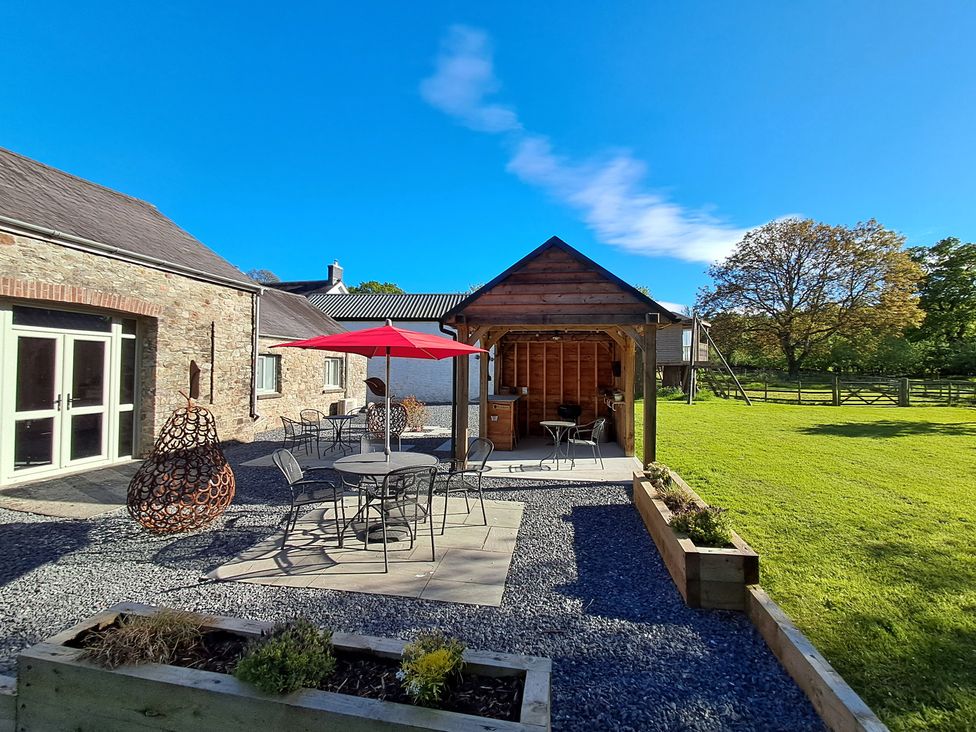 An outdoor patio area with table and chairs at Carreg Cennen Cottage in Llandeilo