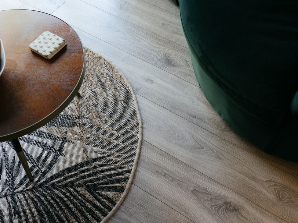 A coffee table with a pad on top and a round rug in a living room at The Observatory Annexe Westcott near Dorking