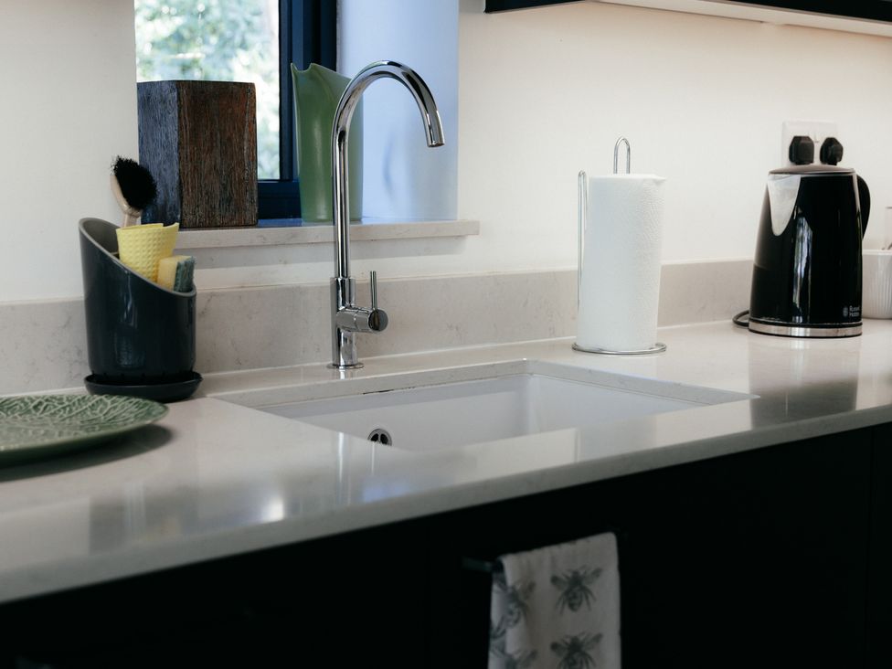 A kitchen sink with faucet and various utensils at The Observatory Annexe in Westcott near Dorking