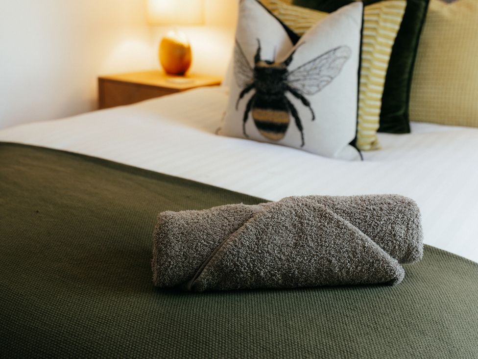 A bed with a towel and pillows at The Observatory Annexe in Westcott near Dorking
