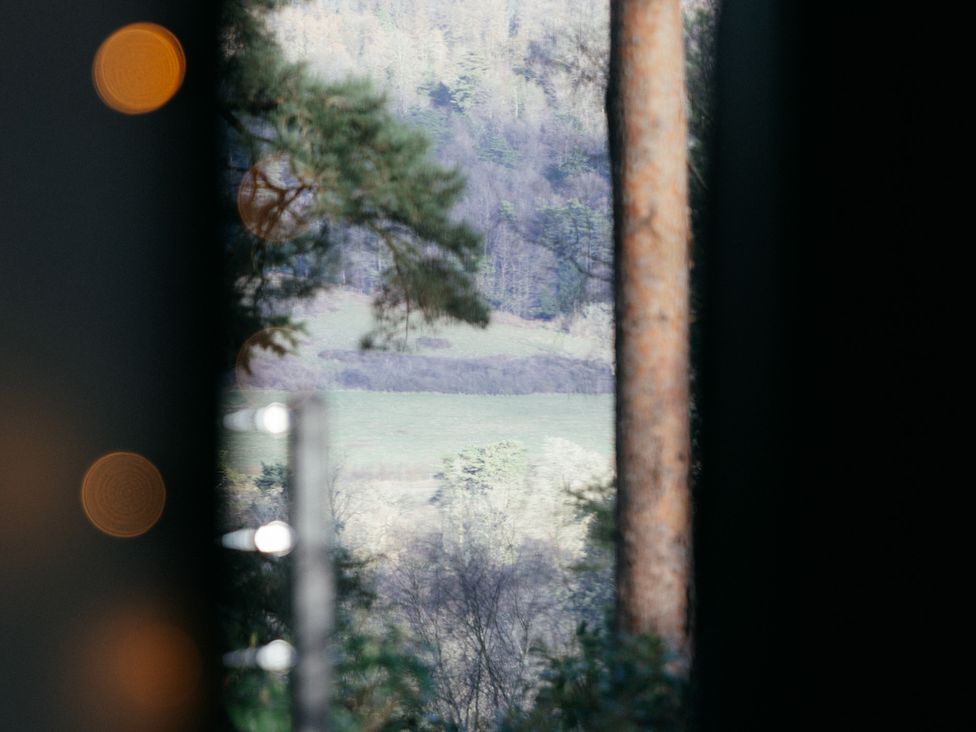 A view of trees and fields through a window at The Observatory Annexe in Westcott near Dorking