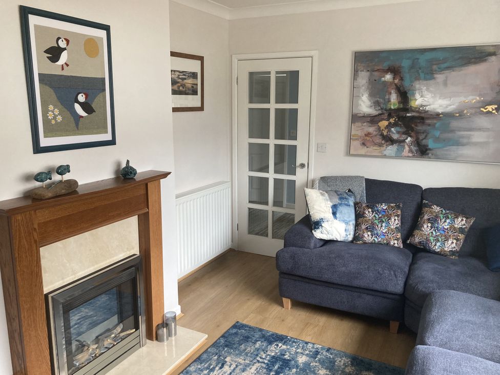 A living room with a fireplace and sofa at Awel Deg, Newport