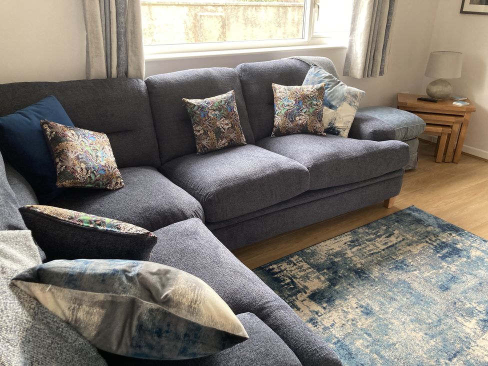 A living room with a sofa and cushions at Awel Deg, Newport, Newport, Pembrokeshire
