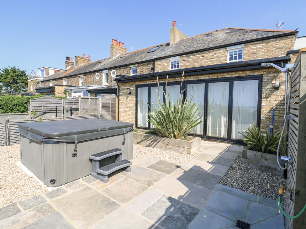 A garden with a hot tub and plants at Coast Guard House Swalecliffe