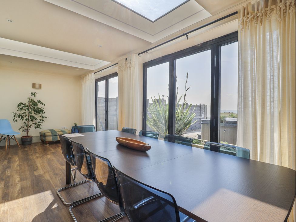 A dining room with a table and chairs at Coast Guard House in Swalecliffe