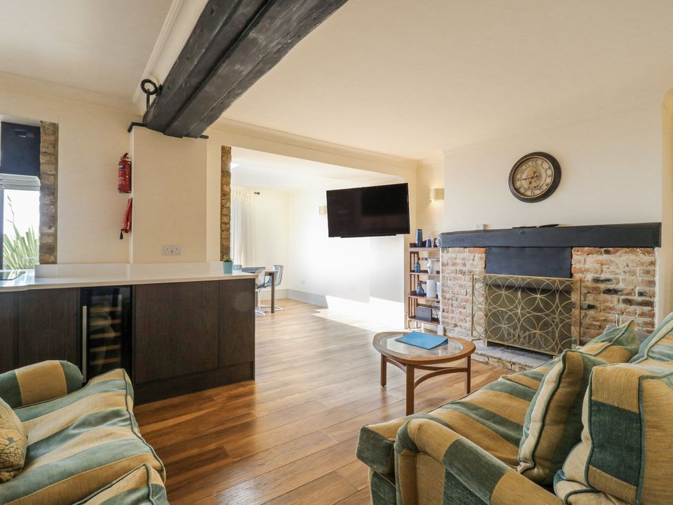 A living room with a coffee table and television at Coast Guard House Swalecliffe