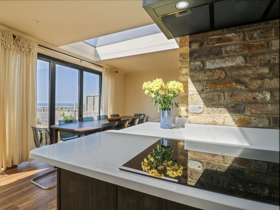 A kitchen with a dining table and chairs at Coast Guard House Swalecliffe
