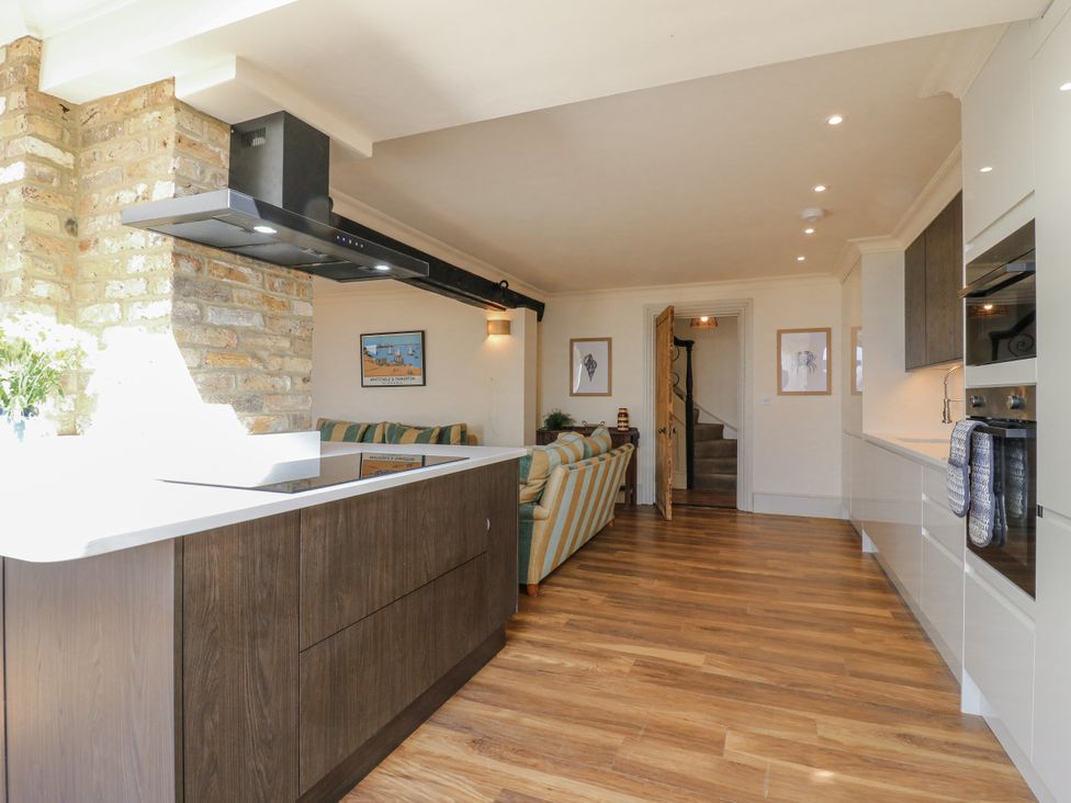 A kitchen with an island and stove at Coast Guard House in Swalecliffe