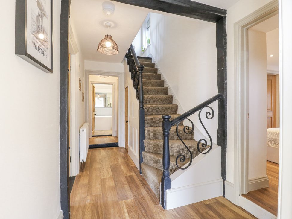 A hallway with a staircase and a door at Coast Guard House Swalecliffe