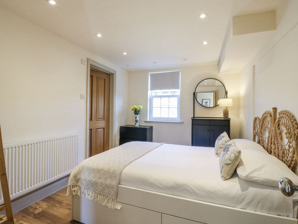 A bedroom with a bed and a wardrobe at Coast Guard House Swalecliffe