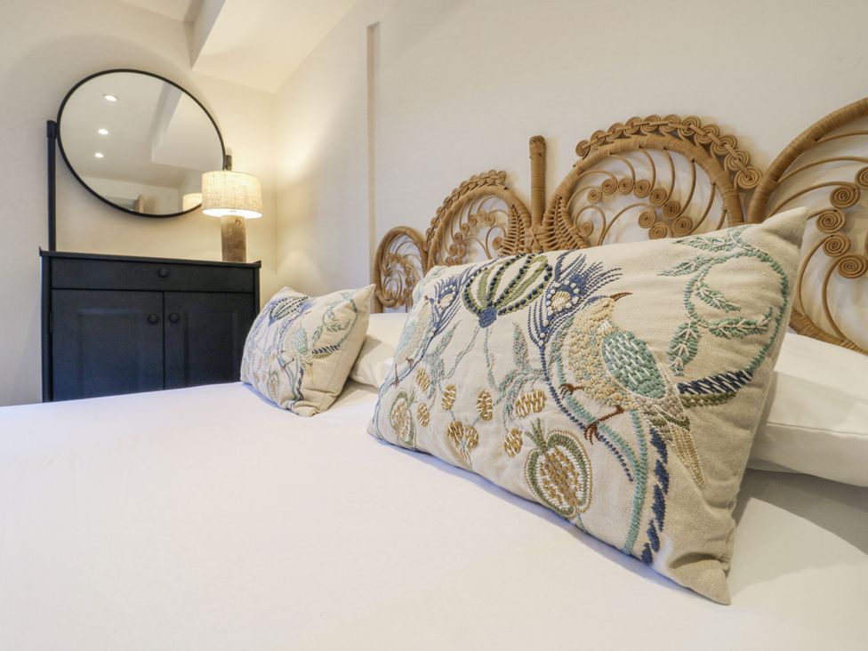 A bedroom with a bed and decorative pillows at Coast Guard House Swalecliffe