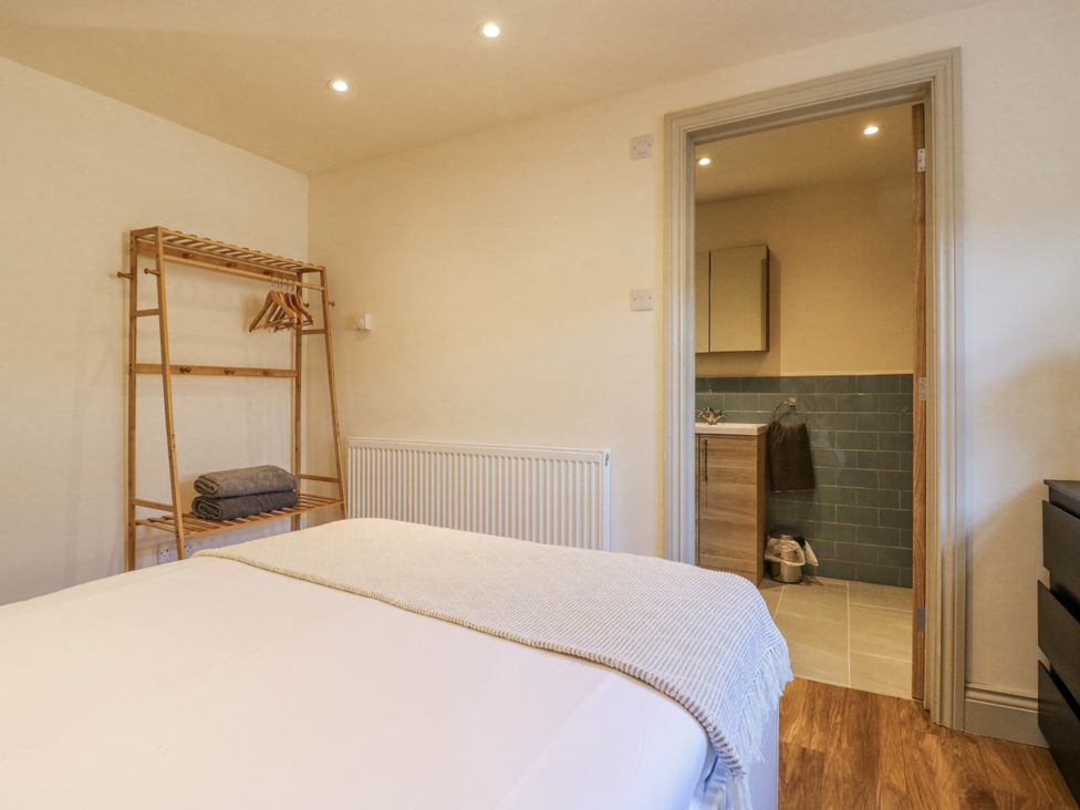 A bedroom with a bed and bamboo rack at Coast Guard House in Swalecliffe