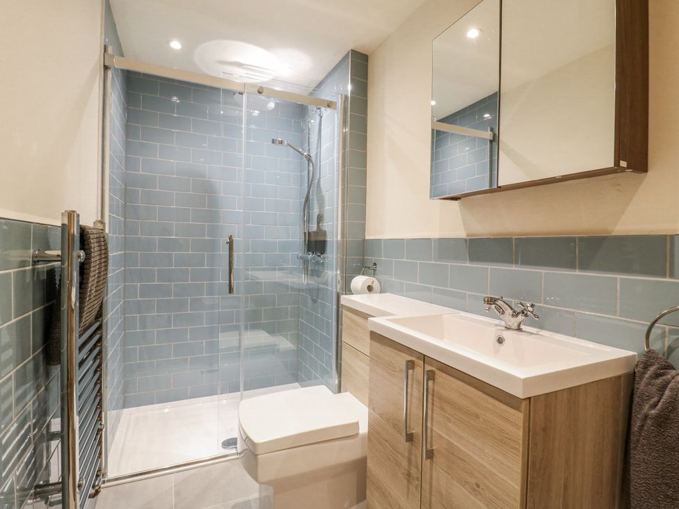 A bathroom with a shower, sink, and toilet at Coast Guard House in Swalecliffe