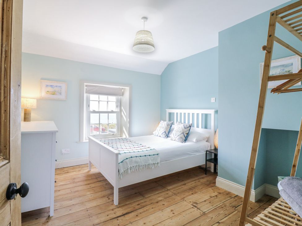 A bedroom with a bed and a dressing table at Coast Guard House in Swalecliffe