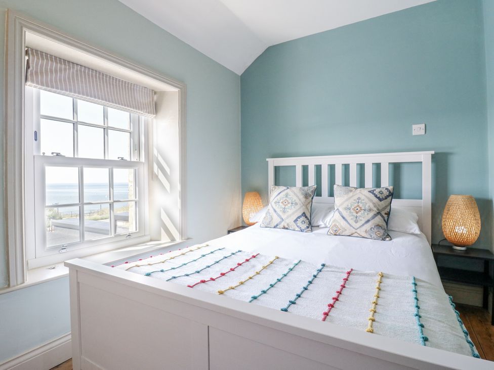 A bedroom with a bed and two lamps at Coast Guard House in Swalecliffe