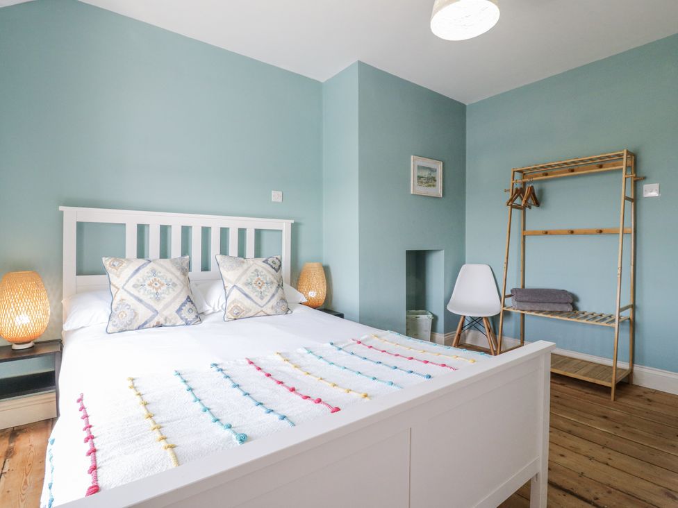 A bedroom with a bed and shelf at Coast Guard House in Swalecliffe