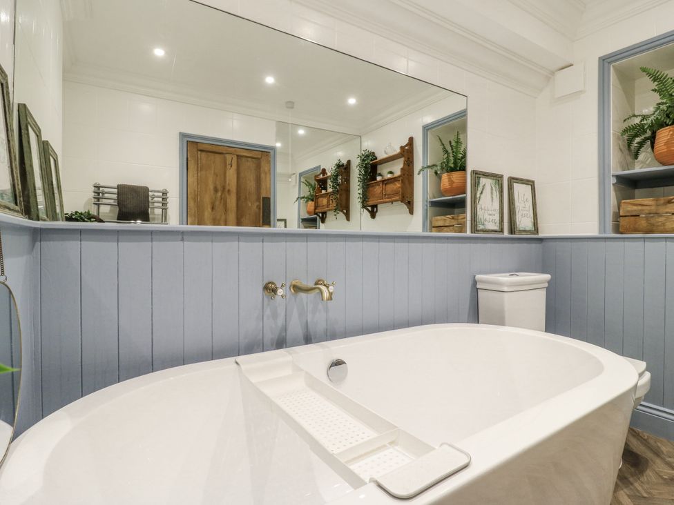 A bathroom with a bathtub and a toilet at Coast Guard House in Swalecliffe