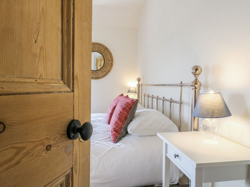 A bedroom with a bed and nightstand at Coast Guard House in Swalecliffe