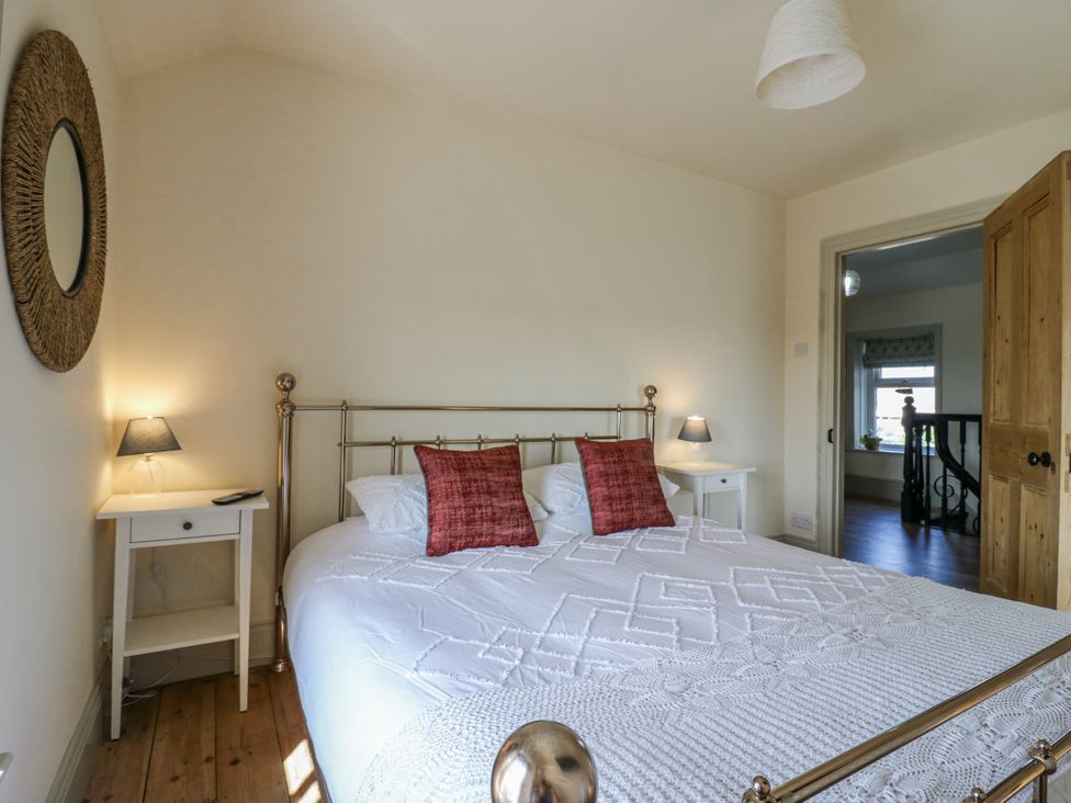 A bedroom with a bed and bedside tables at Coast Guard House in Swalecliffe