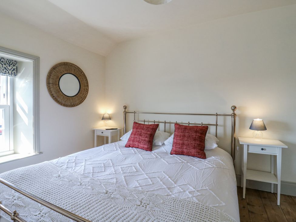 A bedroom with a bed and bedside tables at Coast Guard House Swalecliffe