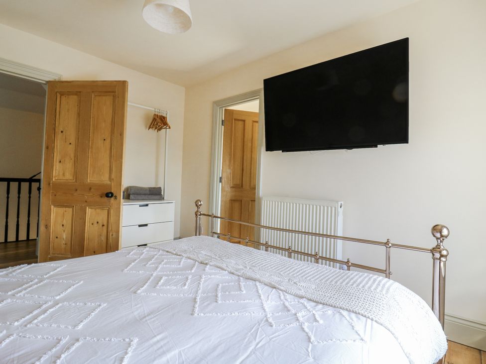 A bedroom with a bed and television at Coast Guard House in Swalecliffe
