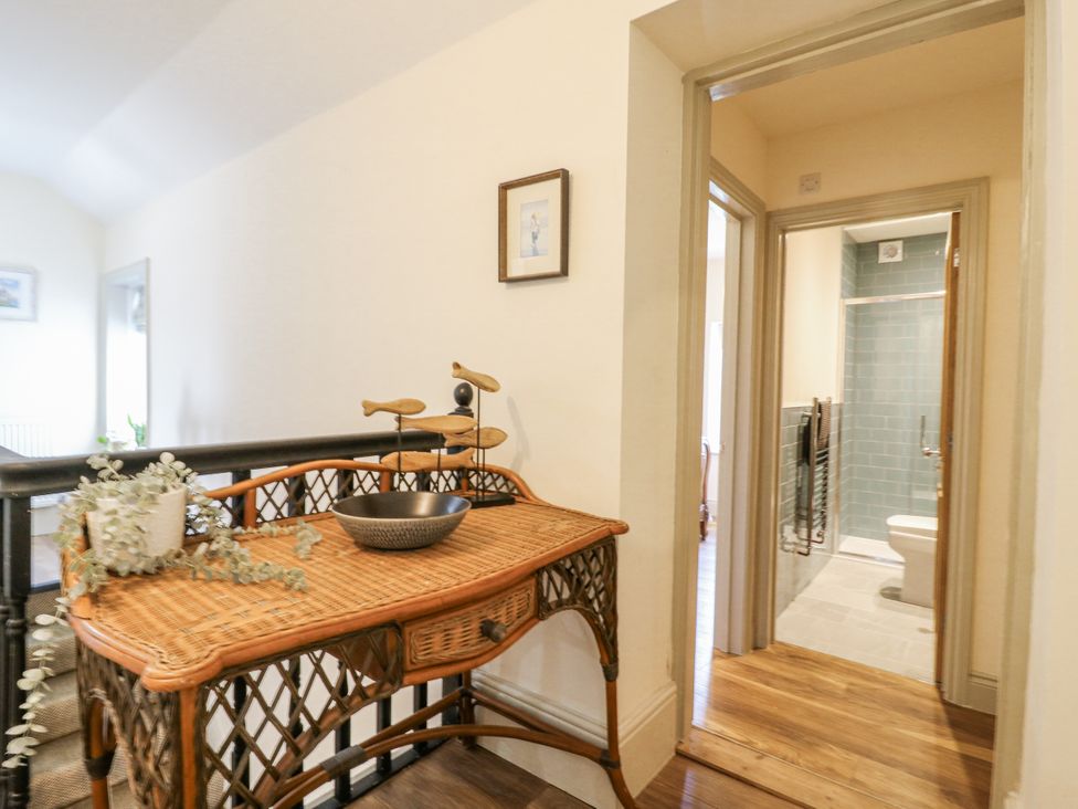 A hallway with a table and a bathroom door at Coast Guard House in Swalecliffe