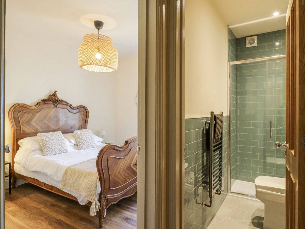 A bedroom with a bed and a bathroom area at Coast Guard House in Swalecliffe