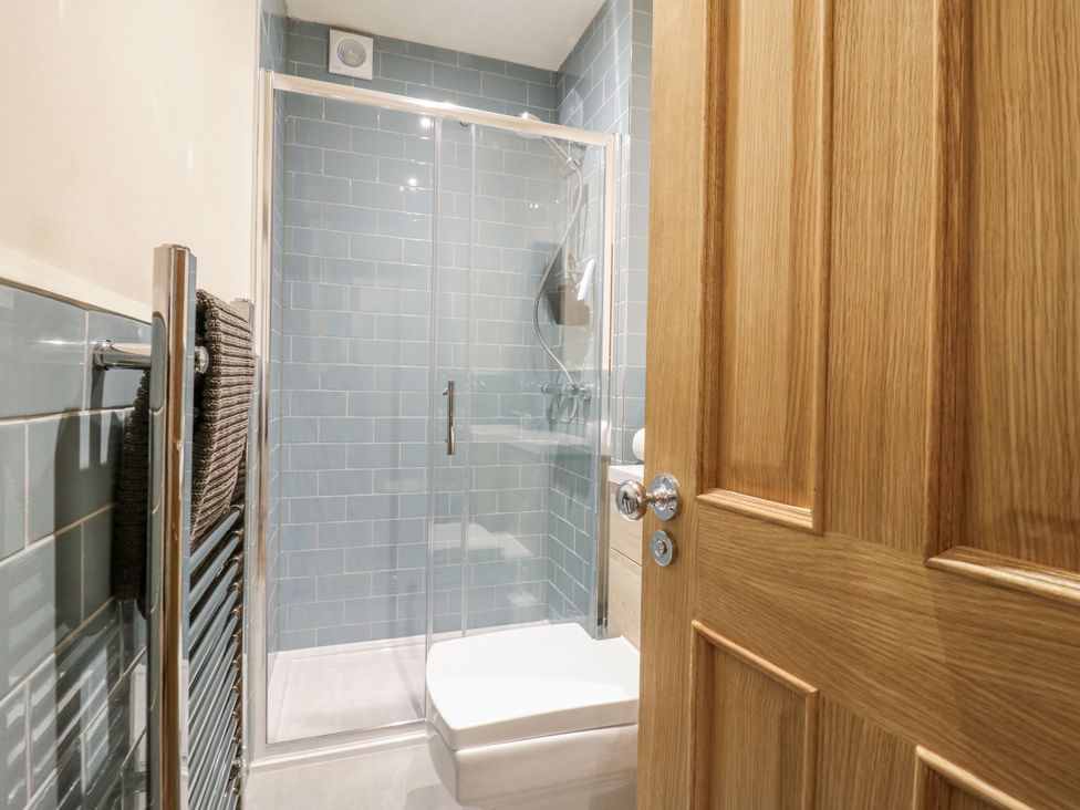 A bathroom with a shower and a towel rack at Coast Guard House Swalecliffe