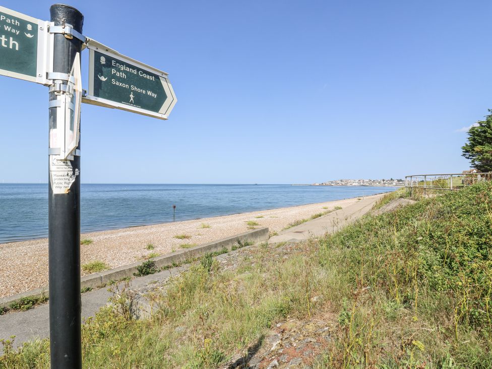 A beach with a signpost leading to walking paths at Coast Guard House Swalecliffe