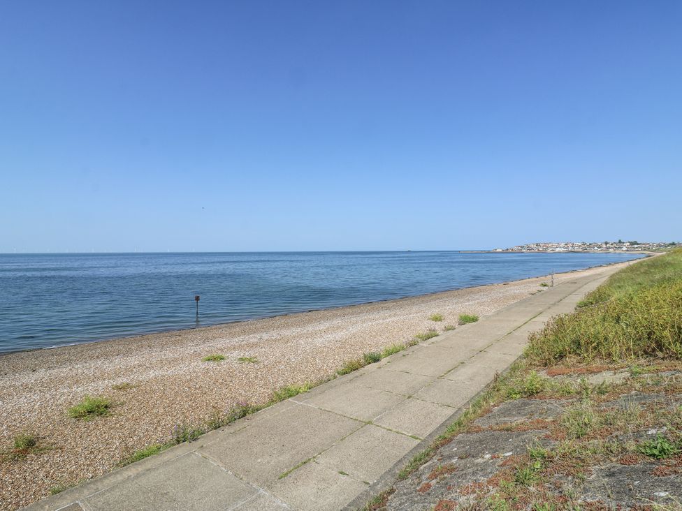 A beach with pebbles and a pathway at Coast Guard House Swalecliffe