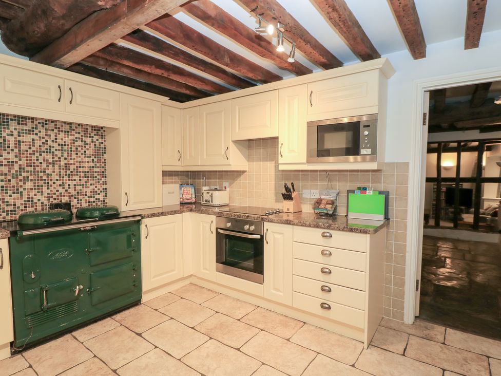 A kitchen with cabinets and a green oven at Butlers Cottage in Burford