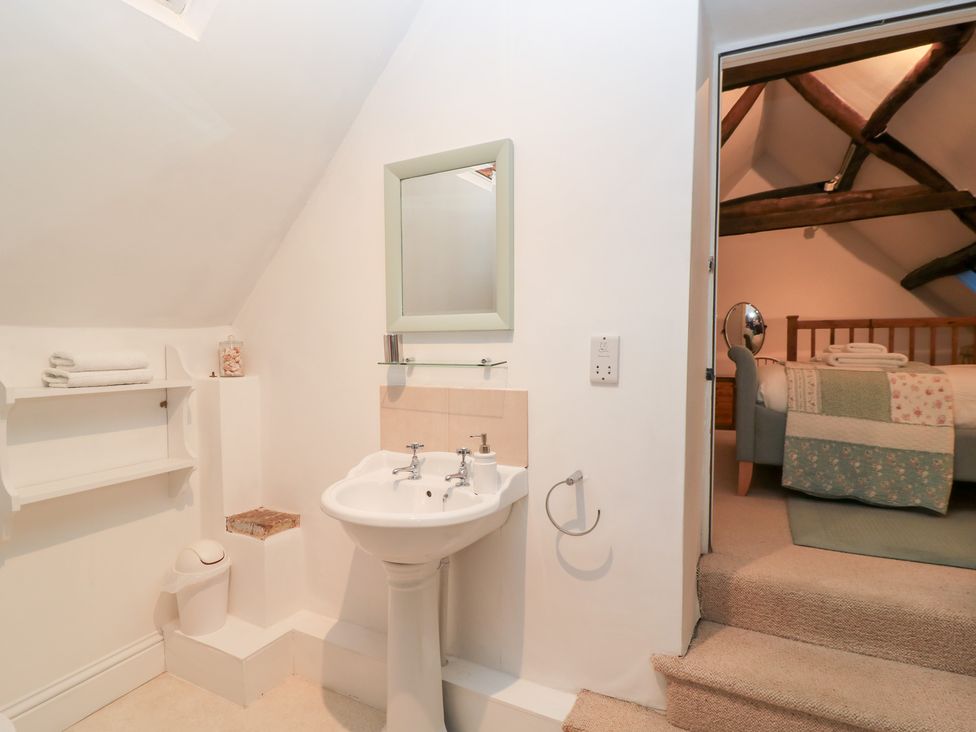 A bathroom with a sink and mirror at Butlers Cottage in Burford